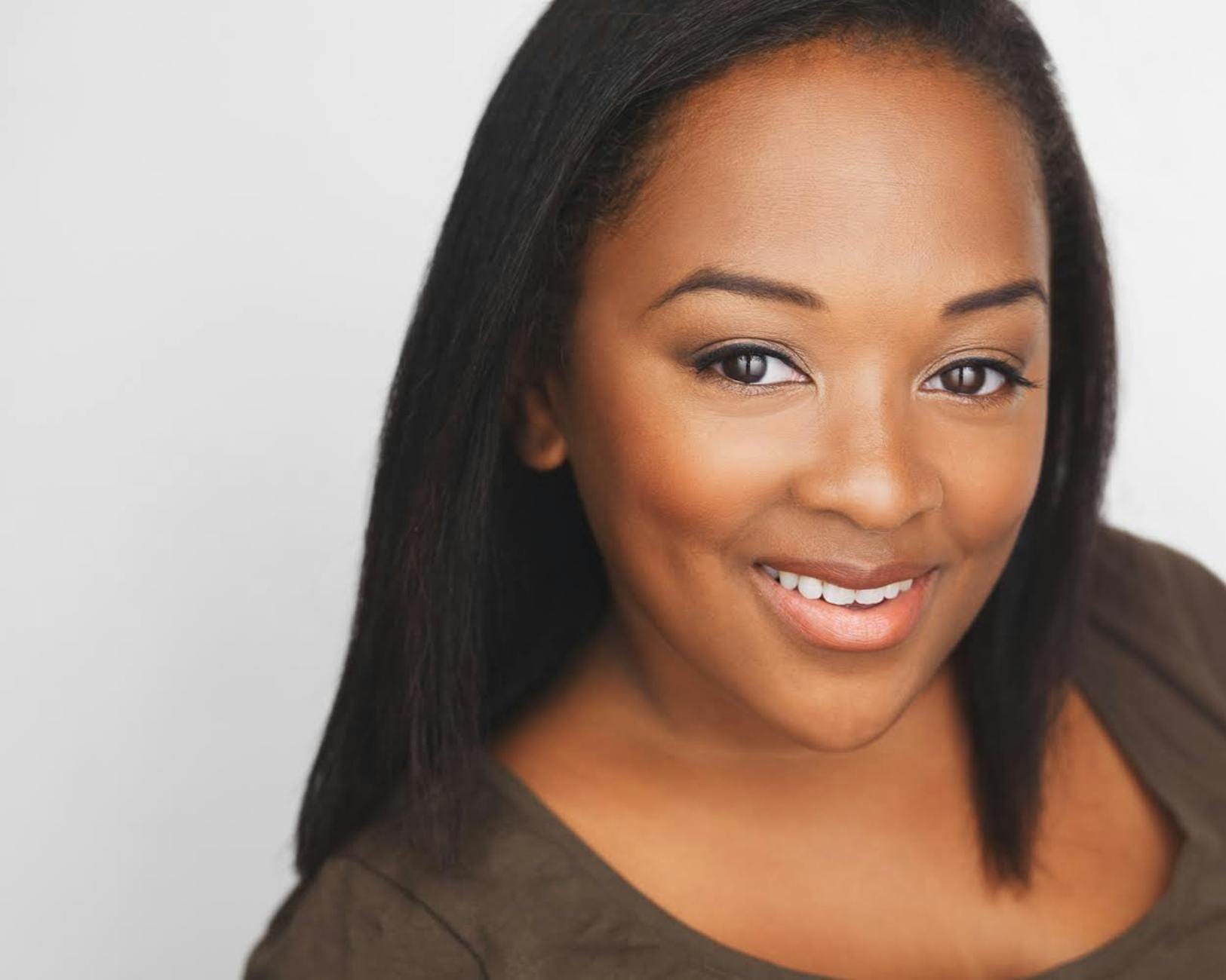 Młoda kobieta uśmiecha się pewnie, portret z naturalnym makijażem