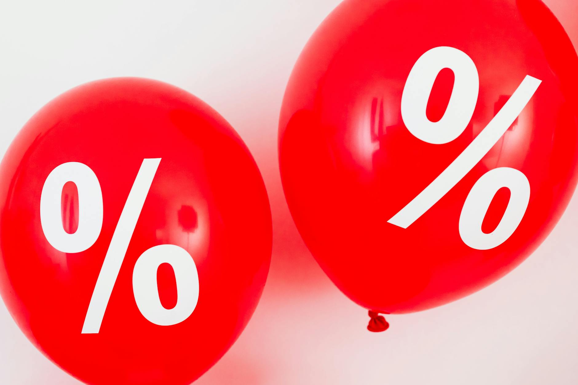 Czerwone balony z białymi symbolami procentu na tle promocji