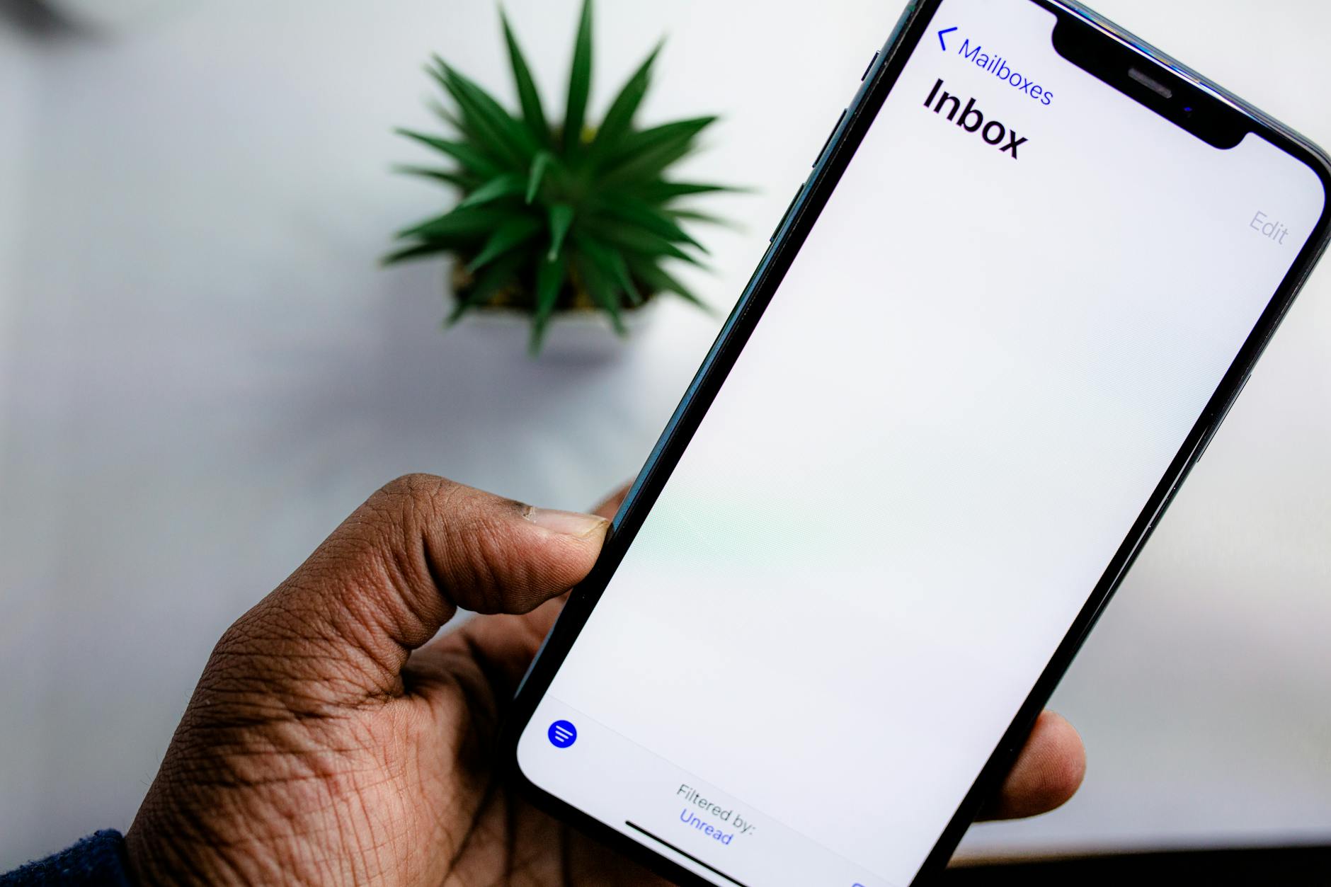 Dłoń trzymająca smartfon z otwartą skrzynką odbiorczą e-mail