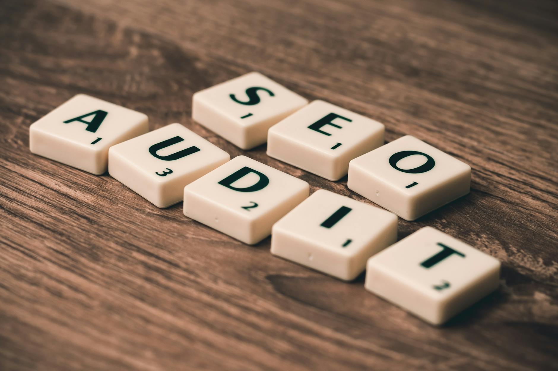Drewniane klocki Scrabble układające się w napis SEO Audit na stole