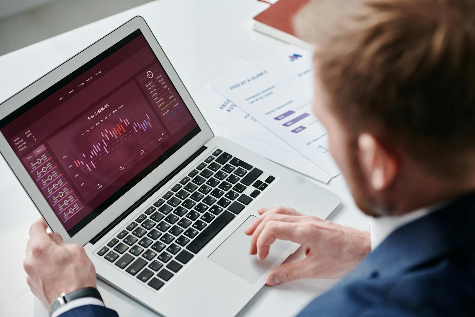 Mężczyzna analizuje pulpit KPI na laptopie w jasnym biurze