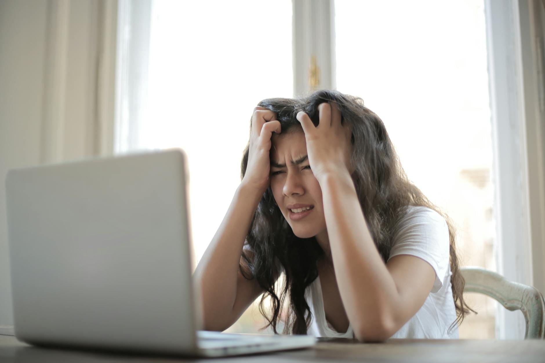 Zestresowana kobieta przy laptopie martwi się brakiem efektów pracy online