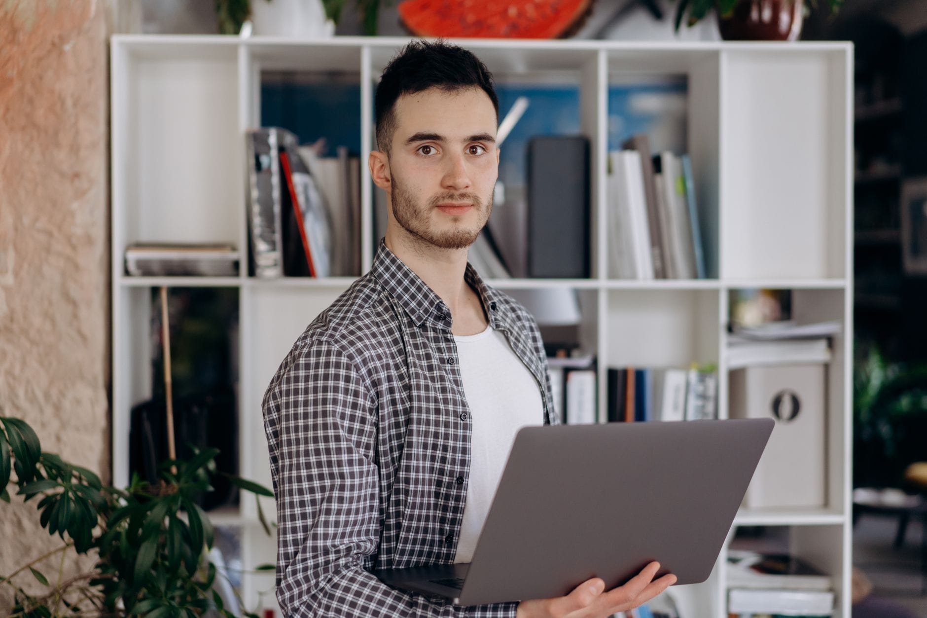 Freelancer z laptopem w nowoczesnym biurze, pewny swojej propozycji wartości