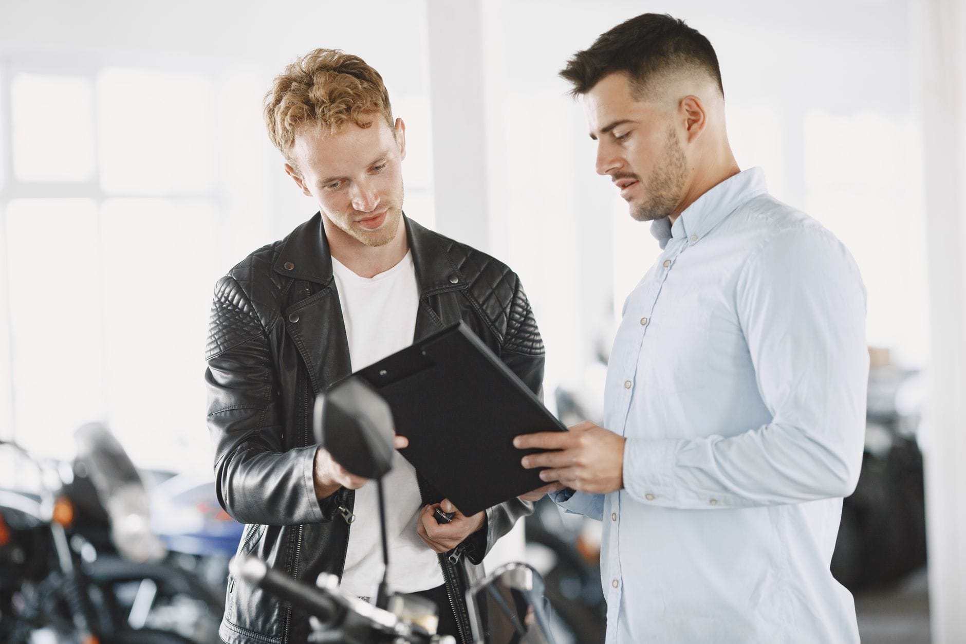 Sprzedawca i klient omawiają wycenę motocykla w salonie