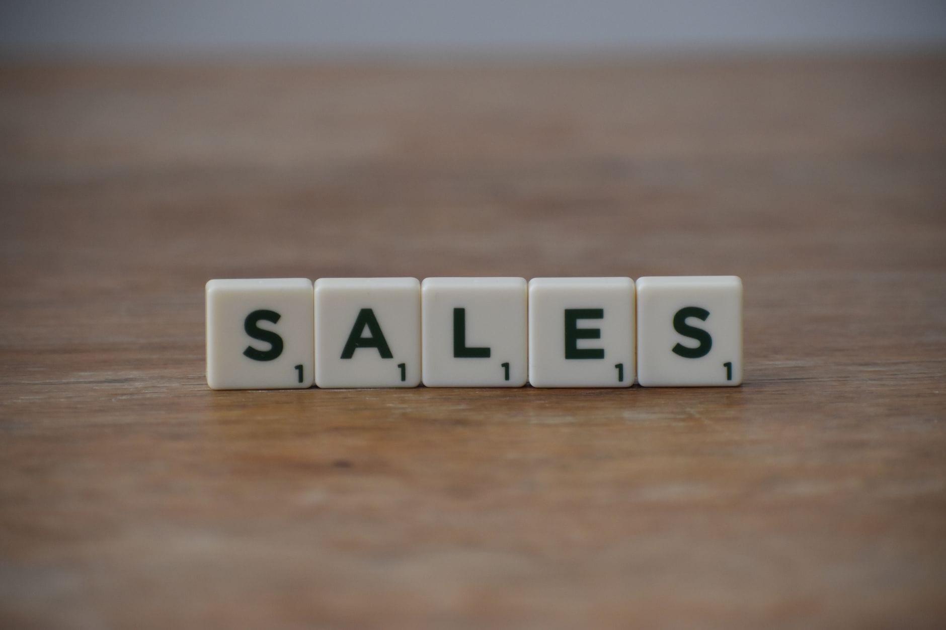 Klocki Scrabble z napisem sales na drewnianym stole