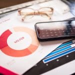 Smartfon na dokumentach biznesowych z wykresami finans