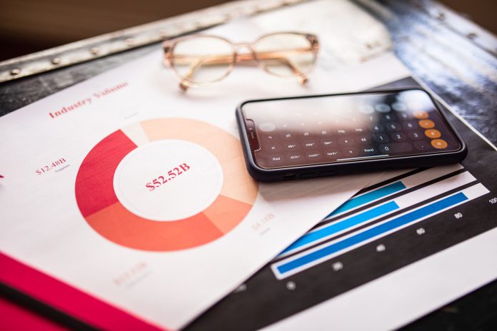 Smartfon na dokumentach biznesowych z wykresami finans Smartfon na dokumentach biznesowych z wykresami finans